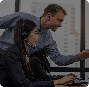 Technical support team assisting a user at a computer, showing customer service and IT support collaboration.